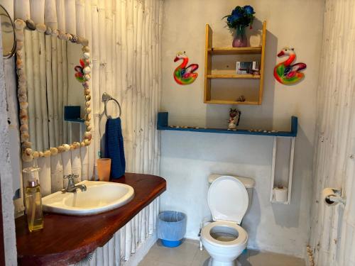 a bathroom with a toilet and a sink at Sea la vie casita in Las Peñitas