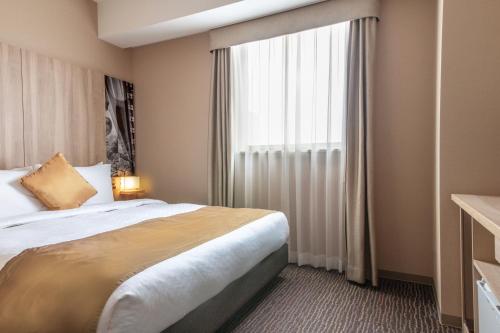 Un pat sau paturi într-o cameră la Hotel Vista Sendai