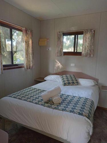 a bedroom with a large bed with two towels on it at Katoomba Falls Tourist Park in Katoomba
