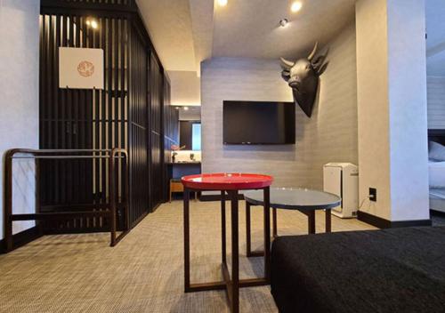 a hotel room with a red table and a tv at Koyado Enn in Toyooka