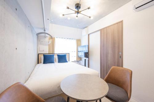 a bedroom with a bed and a table and chairs at Ferio kamata III in Tokyo