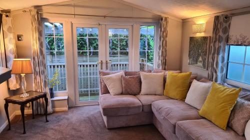 ein Wohnzimmer mit einem Sofa und großen Fenstern in der Unterkunft Sunset View in Gillingham