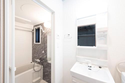 a white bathroom with a sink and a toilet at Ferio kamata III in Tokyo