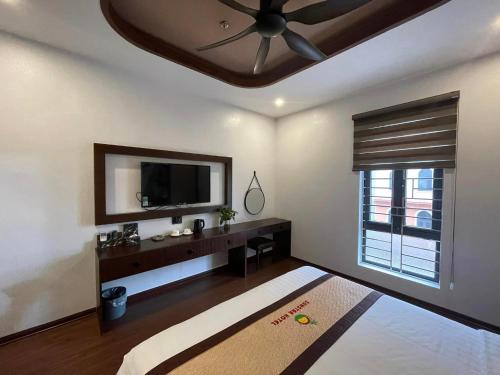 a living room with a ceiling fan and a television at Sunstar Hotel in Ha Long