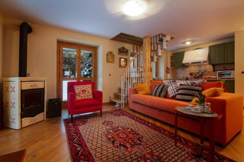 ein Wohnzimmer mit einem roten Sofa und einem roten Sessel in der Unterkunft Appartement Beauregard 1 - Happy Rentals in Les Houches
