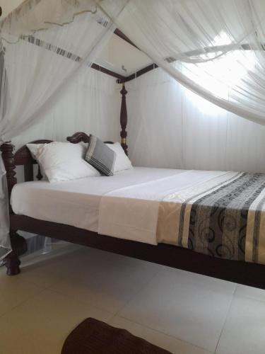 a bed with a canopy in a bedroom at Uyanawatta villa talpe in Talpe