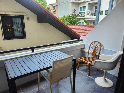 einen Balkon mit einem Tisch und Stühlen auf einem Gebäude in der Unterkunft Jomtien Hill Resort Pratamnak in Pattaya South