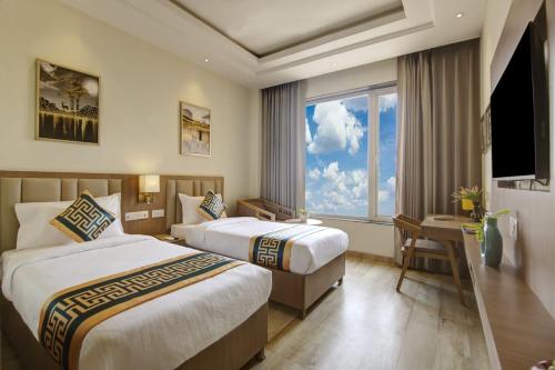 una camera d'albergo con due letti e una finestra di Hotel King Plaza a Nuova Delhi