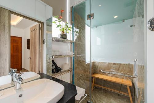 een badkamer met een wastafel en een glazen douche bij California Hotel in Da Lat