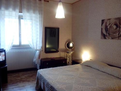 een slaapkamer met een bed, een tv en een raam bij Appartamenti Vista Gransasso in LʼAquila