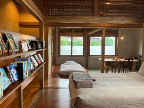 1 dormitorio con 2 camas y una estantería con libros en Miyakojima - House - Vacation STAY 77627v, en Sawada