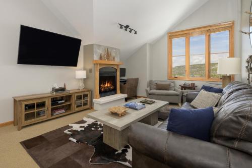 een woonkamer met een bank en een open haard bij Select Unit 1709 - 2BR - Zephyr Mountain Lodge condo in Winter Park