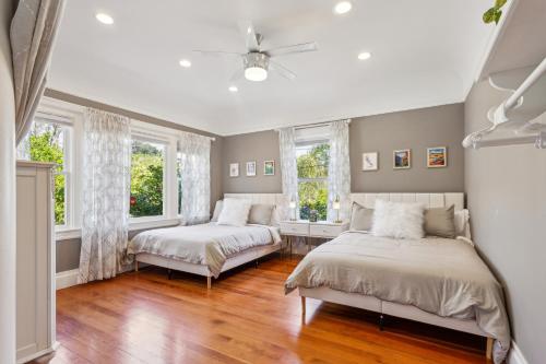 two beds in a room with two windows at Beautiful Spacious Victorian Garden Oasis Central, Gated, Deck, BBQ in San Rafael