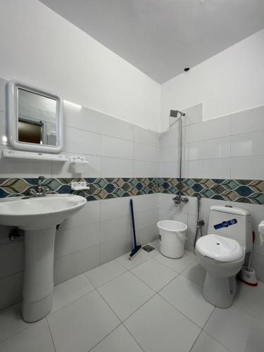 a bathroom with a sink and a toilet and a mirror at Taaj Residence Skardu in Skardu