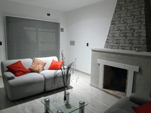 ein Wohnzimmer mit einem Sofa und einem Kamin in der Unterkunft La casa de Flor in San Martín