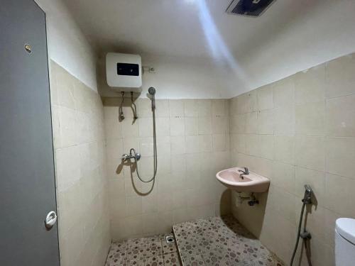 une salle de bain avec douche et lavabo dans l'établissement RedDoorz at Jalan Sam Ratulangi Manado, à Manado