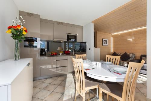 une cuisine et une salle à manger avec une table et des chaises blanches dans l'établissement Appartement L'Outa 209 - Happy Rentals, à Chamonix-Mont-Blanc