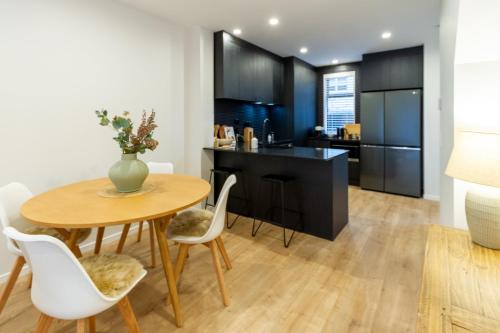 a kitchen and dining room with a table and chairs at Stylish 3 Bedroom Home in Prime City with Garage in Christchurch
