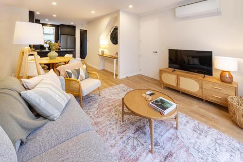 a living room with a couch and a tv at Stylish 3 Bedroom Home in Prime City with Garage in Christchurch