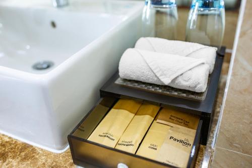 a box filled with towels next to a sink at Pavilion Hotel Da Nang in Da Nang