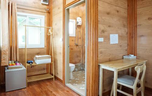 a bathroom with a toilet and a wooden wall at Beung Sampathuan Nakornchaisri Resort in Ban Laem Bua