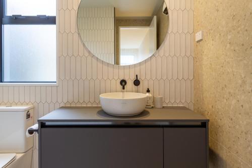Un baño con un lavabo y un espejo. en Stylish 3 Bedroom Home in Prime City with Garage, en Christchurch