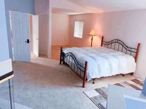 1 dormitorio con 1 cama con colcha blanca en Quiet comfortable whole house en Riverside