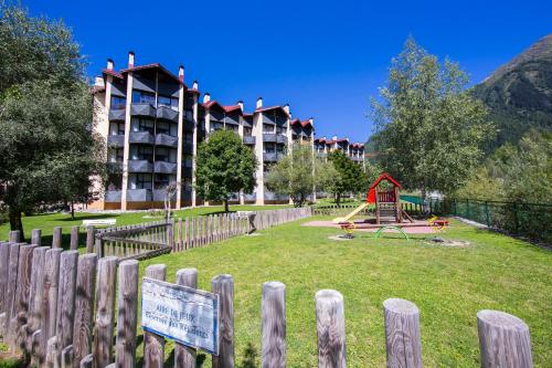 um parque infantil em frente a um grande edifício com um parque em Résidence Grand Roc - Ancolies 028 - Happy Rentals em Chamonix-Mont-Blanc