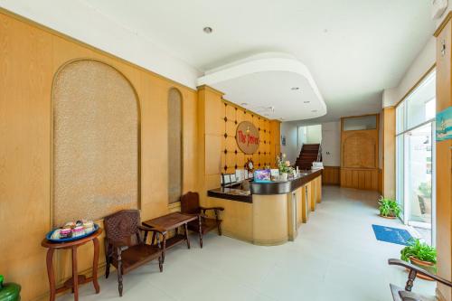 a restaurant with a bar and chairs in a room at The Prince Hotel in Phitsanulok