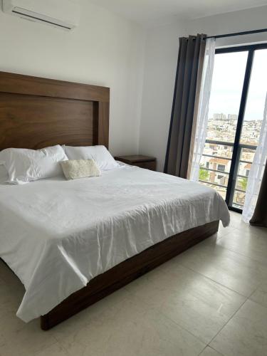 a bedroom with a large bed with a large window at Departamento en Mazatlán in Mazatlán