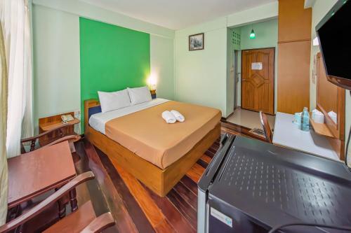 a small room with a bed and a television at The Prince Hotel in Phitsanulok