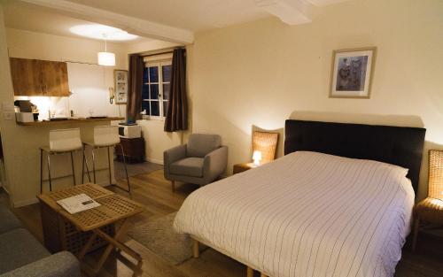 une chambre avec un lit et une chaise et une cuisine dans l'établissement Le Studio du Gouverneur, à Honfleur
