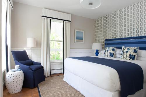 a bedroom with a blue bed and a blue chair at 76 Main Ink Press Hotel in Nantucket