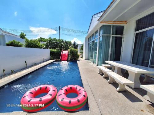 a swimming pool with two inflatable tubes in a house at Beachtown Cha-Am Private Poolvilla from beach 2km in Cha Am