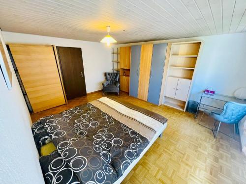 een slaapkamer met een bed, een bureau en een stoel bij Sehr gemütliches und gepflegtes Zimmer 8 Km von Bern-City in Köniz