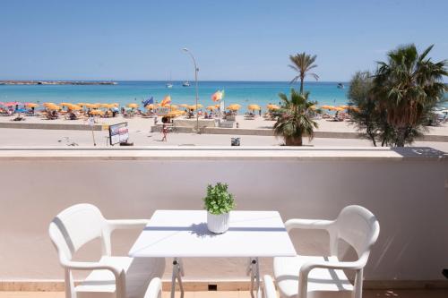 a table and chairs with a view of the beach at Appartamento Conturrana Sul Mare in San Vito lo Capo