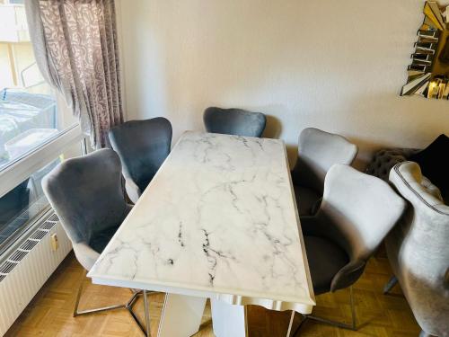 einen Marmortisch und Stühle in einem Zimmer in der Unterkunft Sehr gemütliches und gepflegtes Zimmer 8 Km von Bern-City in Köniz