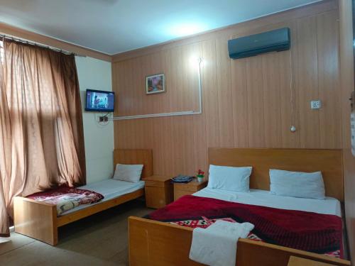 Habitación de hotel con 2 camas y TV en SEE MOTEL, en Muzaffarabad