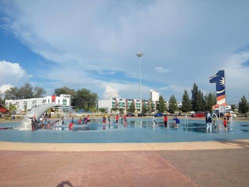 a group of people playing in a fountain at ARK Malacca Hotel in Malacca
