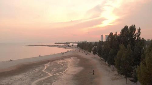 a group of people walking on the beach at ARK Malacca Hotel in Malacca