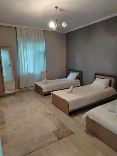 a bedroom with two beds and a chandelier at Gabala rent House in Gabala