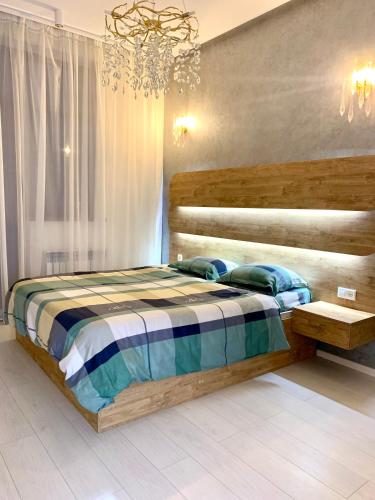 a bedroom with a wooden bed and a chandelier at - Daniels Suite - Modern&Central - in Tashkent
