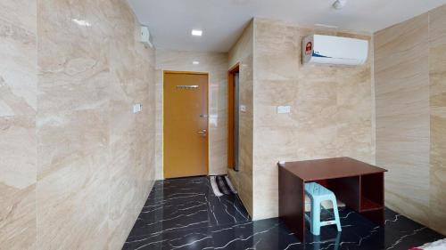 a hallway with a wooden table and a blue stool at ARK Malacca Hotel in Malacca