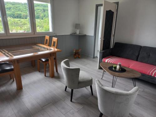 a living room with a couch and a table and chairs at Gite des forets in Trésauvaux