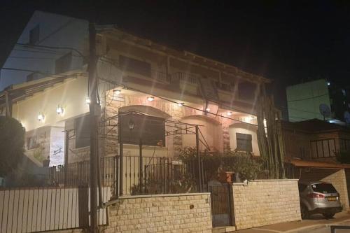 a house with lights on the front of it at night at חלומות בגבעה Dreams On The Hill in El ‘Affūle