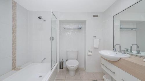 Un baño con inodoro, lavabo y ducha. en Studio 908 - Panoramic Ocean Views On The Strand, en North Ward