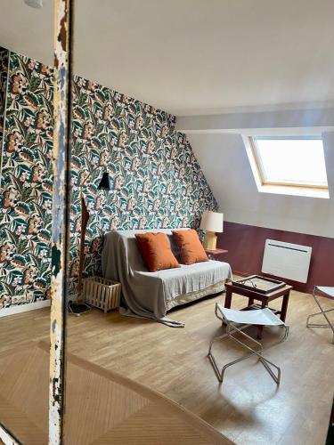 une chambre avec un lit et une chaise dedans dans l'établissement Les Mouettes de Wimereux, à Wimereux