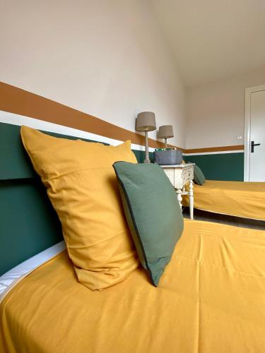 - une chambre avec 2 lits dotés d'oreillers jaunes et verts dans l'établissement Les Mouettes de Wimereux, à Wimereux