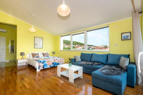 a living room with a blue couch and a bed at KAIROS in Bilice
