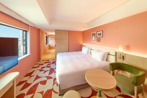 a hotel room with a large bed and a table at The Royal Park Hotel Ginza 6-Chome in Tokyo